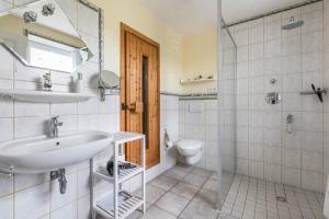 a bathroom with a sink and a shower and a toilet at Auszeit Il am Deich auf Nordstrand in Nordstrand