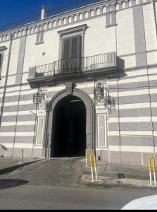 a large white building with a doorway and a balcony at Mediterraneo Apartment in Ercolano