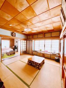 a large room with a table and a bed at T&T Fujiyama Guest House in Fujiyoshida