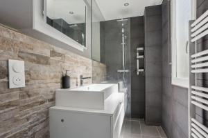 a bathroom with a white sink and a shower at 9-minute walk from La Défense - 1 bedroom in Courbevoie