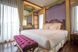1 dormitorio grande con 1 cama grande y un banco púrpura en Chankam Boutique Hotel, en Chiang Mai