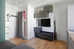 a living room with a flat screen tv on a wall at 9-minute walk from La Défense - 1 bedroom in Courbevoie