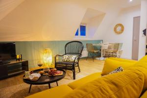 a living room with a yellow couch and a table at -LE CHALET- Joli cocon au centre de Concarneau in Concarneau