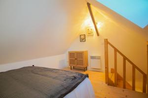 a bedroom with a bed and a wooden staircase at -LE CHALET- Joli cocon au centre de Concarneau in Concarneau