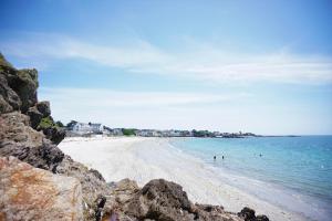 a sandy beach with people swimming in the water at -LE CHALET- Joli cocon au centre de Concarneau in Concarneau