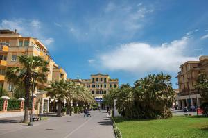une rue dans une ville avec des palmiers et des bâtiments dans l'établissement Maremè Guest House Ostia, à Lido di Ostia