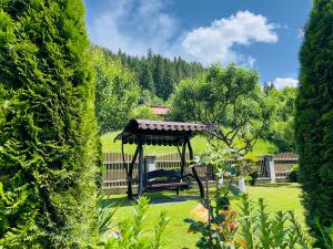 a gazebo in the middle of a garden at Căsuțe Poiana Largului in Poiana Largului
