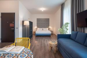 ein Wohnzimmer mit einem blauen Sofa und einem Bett in der Unterkunft Palazzo Del Porto in Genua