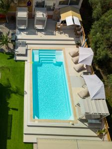 uma vista superior para uma piscina com cadeiras e guarda-sóis em Modular Bungalows With Heated Pool Artemis Greece em Artemida