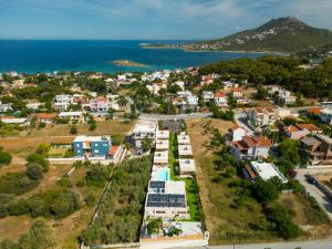 an aerial view of a small town next to the ocean at Modular Bungalows With Heated Pool Artemis Greece in Artemida +104 photos