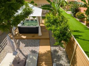 a small backyard with a hot tub and trees at Modular Bungalows With Heated Pool Artemis Greece in Artemida