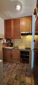 een keuken met houten kasten, een wastafel en een fornuis bij Mini villa jardin 50 m plage in Borgo +25 foto's