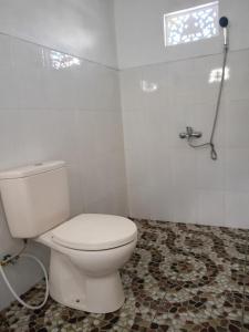 une salle de bain avec des toilettes blanches et une douche dans l'établissement Batur Volcano Cottage, à Kubupenlokan