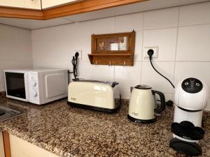 a kitchen counter with a coffee maker and a toaster at Azor International Apartment II in Ponta Delgada