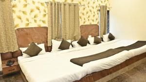 2 camas grandes en una habitación con cortinas en Hotel Kaka Inn, en Ajmer