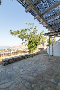 a patio with a pergola overlooking the ocean at Porto Blue Horizon in Agios Ioannis