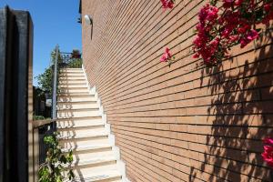 a staircase leading up to a brick wall with pink flowers at Art of Living in Settebagni