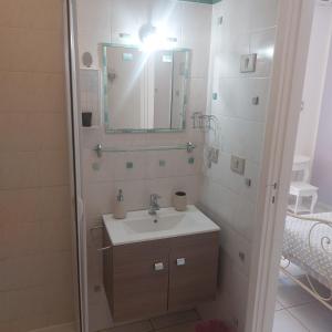y baño con lavabo y espejo. en Il Melangolo, en SantʼAntìoco