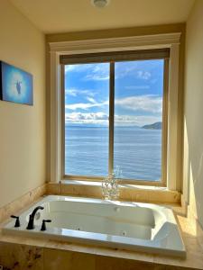 baño con bañera grande y ventana grande en Stunning House with Views of Puget Sound! Ideal for Family Reunions en Edmonds