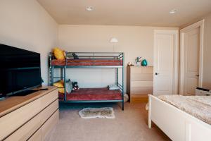 1 dormitorio con 2 literas y TV de pantalla plana en Stunning House with Views of Puget Sound! Ideal for Family Reunions en Edmonds