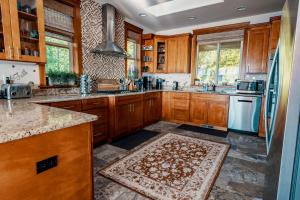 una cocina con armarios de madera y una alfombra en el suelo en Stunning House with Views of Puget Sound! Ideal for Family Reunions, en Edmonds