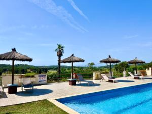 a swimming pool with chairs and umbrellas at Can Pitu Ferriol in Montrás