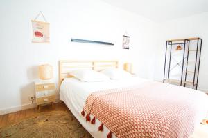 a bedroom with a bed with a red and white blanket at -BOSCO- Elegant T3 avec balcon et vue sur le port in Concarneau