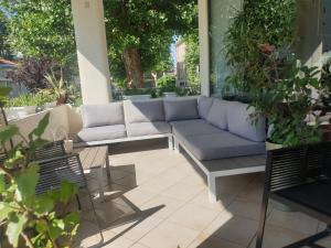 eine Couch auf einer Terrasse mit Pflanzen in der Unterkunft Hotel Bianca Vela in Rimini