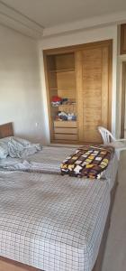 a bedroom with two beds and a cabinet at ola blanca1 in Dar Hamida