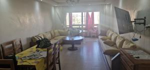 a living room with a couch and a table at ola blanca1 in Dar Hamida