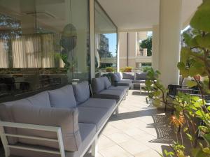 una fila de sofás en un patio con plantas en Hotel Bianca Vela, en Rímini