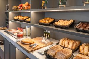 une boulangerie avec du pain et d'autres aliments sur les étagères dans l'établissement B&B HOTEL Lleida, à Lleida