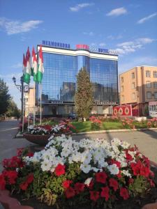 un bâtiment avec beaucoup de fleurs devant lui dans l'établissement Hotel Shirin, à Isfara