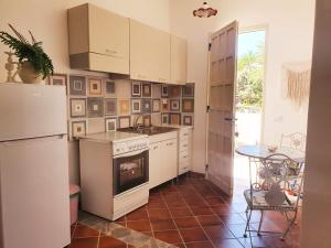 a kitchen with a stove and a refrigerator and a table at Villa Migliore in Lampedusa +14 photos