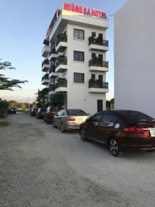 um parque de estacionamento com carros estacionados em frente a um hotel em HOÀNG SA HOTEL em Cam Ranh