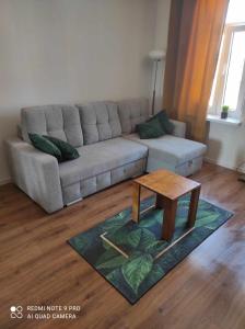 ein Wohnzimmer mit einem Sofa und einem Couchtisch in der Unterkunft Apartament Lago in Mrągowo