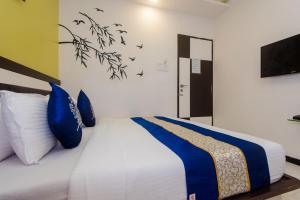1 dormitorio con 1 cama con almohadas azules y TV en OYO Blue Pearl Residency Near Chhatrapati Shivaji International Airport, en Bombay