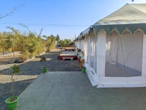 a tent with a picnic table in a yard at Kutch Leela Resort in Mandvi