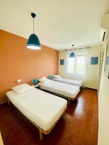 Zimmer mit 3 Betten und 2 Leuchten in der Unterkunft GRAN RESERVA 5 Ático in Empuriabrava