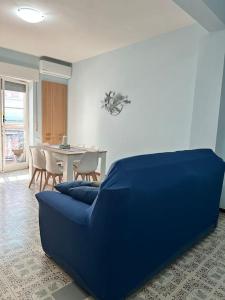 Un sofá azul en una sala de estar con una mesa. en appartamento encaty, en Maiori