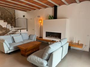 Una sala de estar con dos sofás y una chimenea. en Villa Masia Capdet, en Sant Pere de Ribes