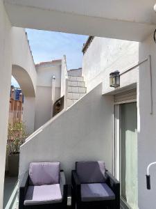 zwei lila Stühle auf dem Balkon eines Gebäudes in der Unterkunft GRAN RESERVA 5 Ático in Empuriabrava + 23 Fotos