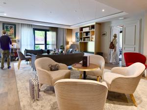 uma sala de estar com um sofá, uma mesa e cadeiras em ibis Maisons Laffitte em Maisons-Laffitte