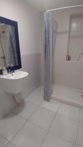 Un baño blanco con lavabo y ducha. en Cardeñosa habitaciones, en Madrid