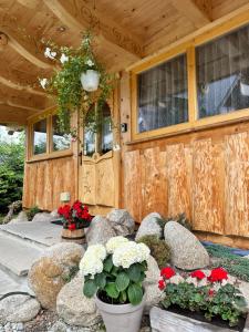 a wooden cabin with flowers in front of a door at Domki u Magdy in Zakopane