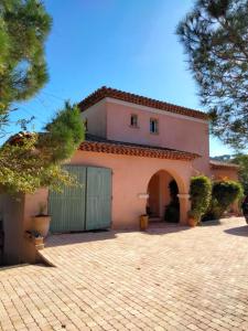 une maison rose avec un portail et une allée dans l'établissement Villa Aurea, à Hyères