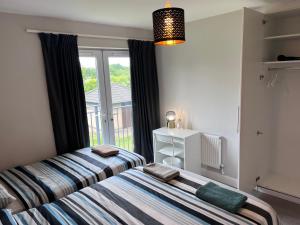 two beds in a bedroom with a window at Lovely Twin Room 15 mins from Dublin Airport & Dublin City in Dublin