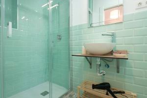 uma casa de banho com um lavatório e uma cabina de duche em vidro. em Rosarioseis LOFT CORRAL DEL CARBÓN em Granada