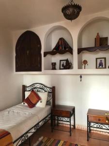a bedroom with a bed and a table and shelves at Dar Fezna - top location, stunning 360 views in Chefchaouen