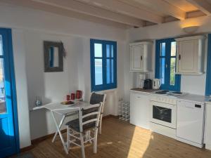 a kitchen with a table and a small table with chairs at George's Traditional House in Agios Georgios